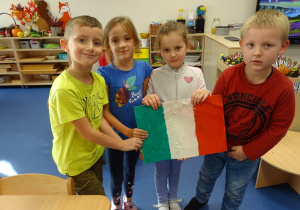 dzieci z flagą wyklejoną plasteliną
